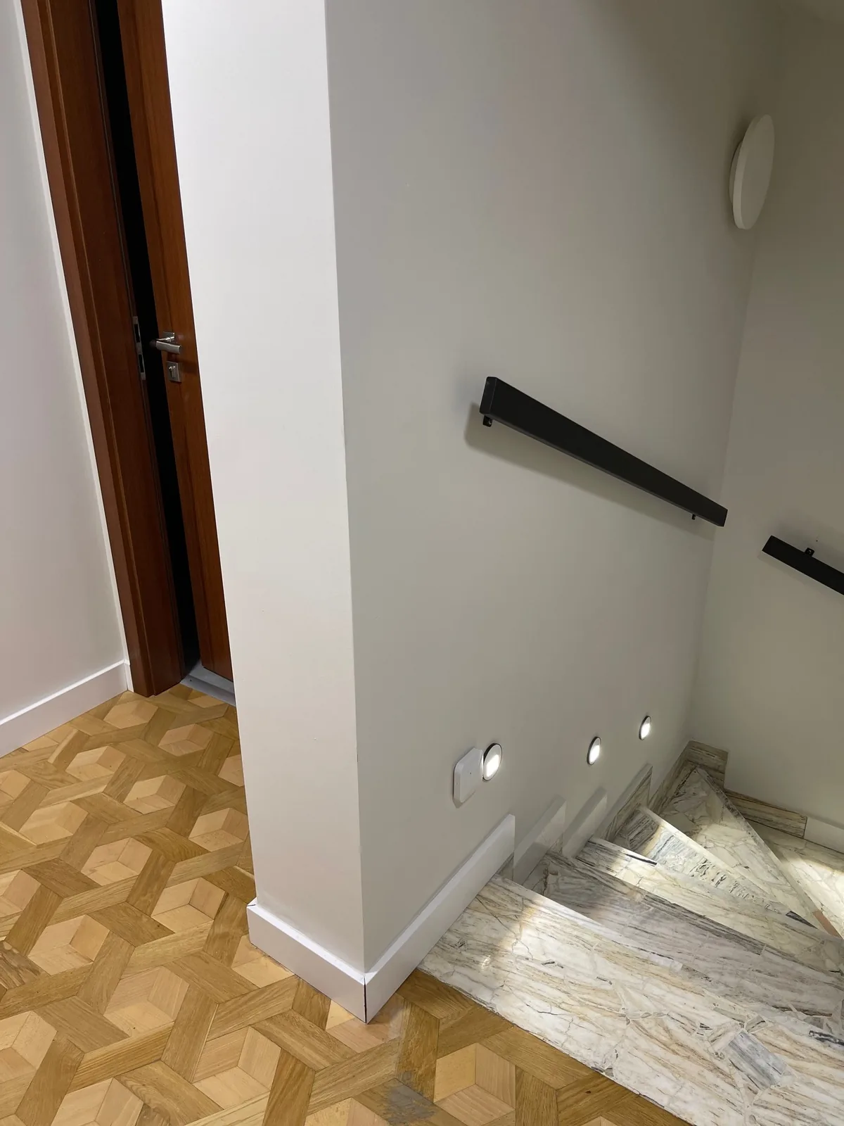 Podest klatki schodowej z geometrycznym parkietem